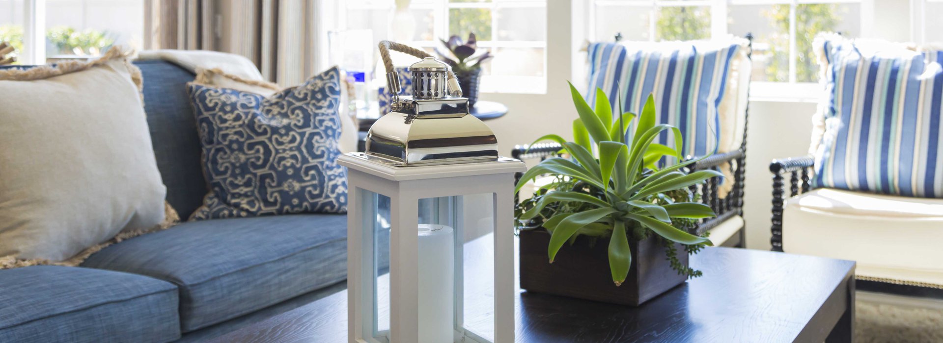open-airy-living-room-a-beautiful-couch-and-a-coffee-table-with-a-lantern-on-it